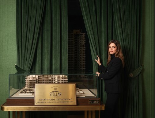 Platinum Stellar Santacruz West Near rajesh khanna garden – Presidential Suites luxury apartment under construction with a woman guiding curtains to reveal Building elevation